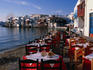 Tables laid out at a waterfront restaurant on Alevkantra, a small sand beach in Mykonos.