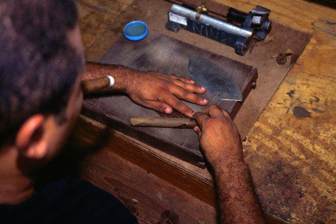 Man making cigars by hand.