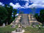 A visitor strolls across the Complex Q plaza in Mayan Tikal. There are more than 41000 temples or pyramids in Tikal. The oldest date from the Pre-classic period (800 BC), and the most recent from the Post-classic period (900 AD).