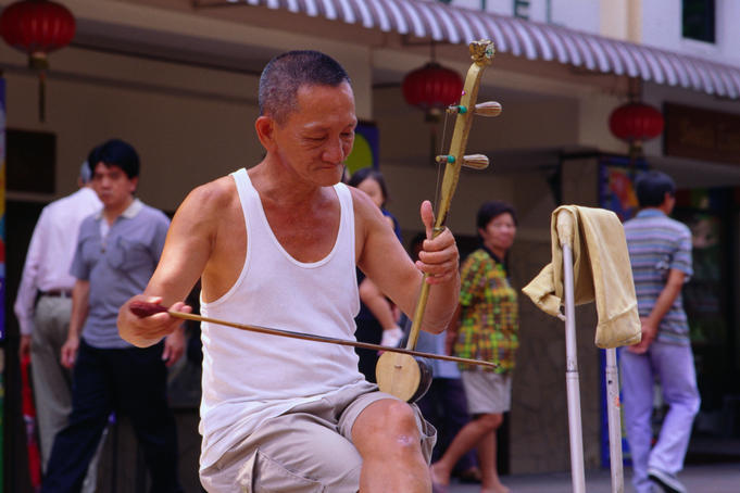 Busker playing traditionl stringed instrument.