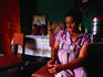 Favela Paraisopolis, slum or shanty town: Old woman sitting inside - Sao Paulo, Sao Paulo