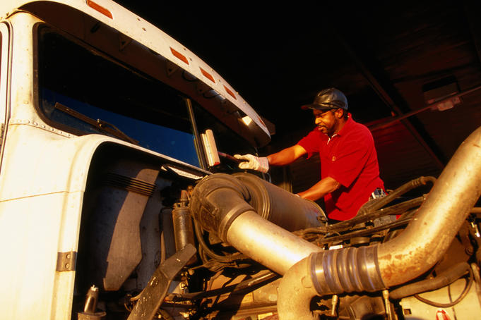 Truck driver cleaning window of vehicle on Route 80 near Lovelock east of Reno.