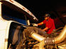Truck driver cleaning window of vehicle on Route 80 near Lovelock east of Reno.