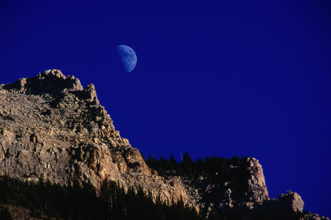 Moonrise over a rocky mountain ridge in Waterton National Park.