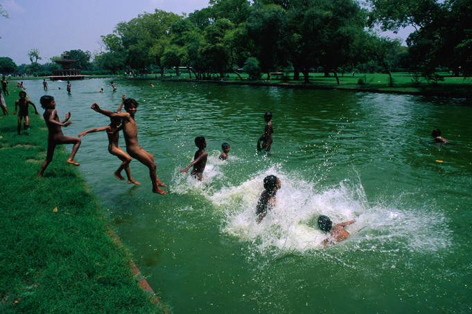 Young boys jump into a pond that lines the Rajpath or Kings Way in Delhi.