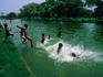 Young boys jump into a pond that lines the Rajpath or Kings Way in Delhi.