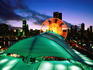 Overhead of Navy Pier and Ferris wheel with city skyline at dusk.