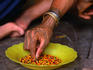 Intricately tattooed hand of a Mentawai Shaman stringing beads for a necklace on Siberut Island in West Sumatra.