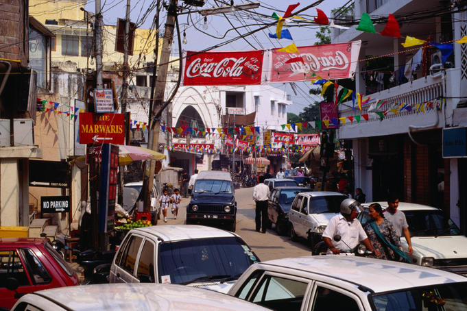 Advertising banners and flags overhang a street in Delhi.