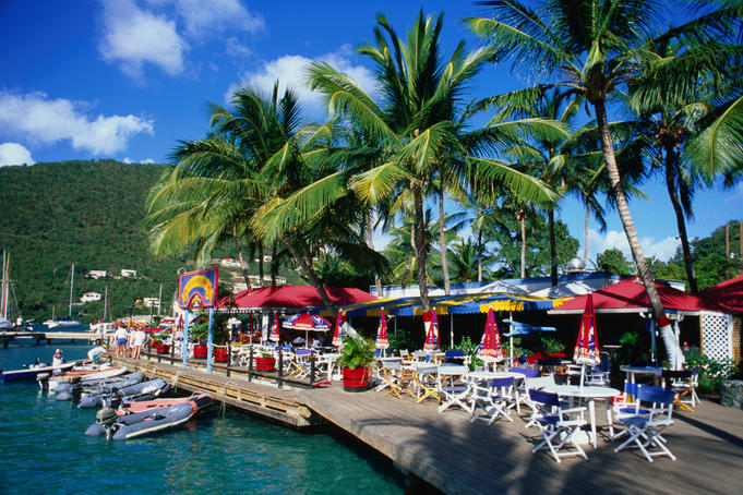 Shops and restaurants, under the shade of palm trees, on the waterfront at West End.