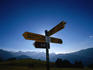 Hiking sign post near Hahnenmoospass with Bernese Alps in the background.