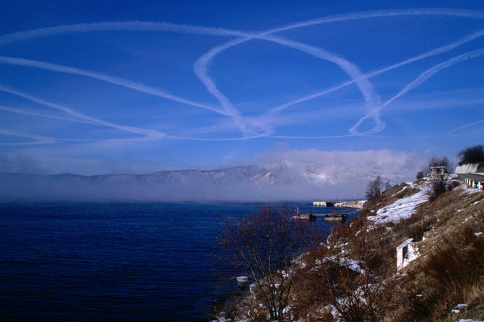 A stream of aeroplane smoke patterns the sky over Lake Baikal at Listvyanka.