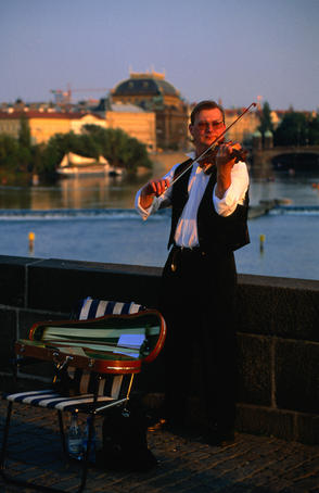 A violinist busks on the Charles Bridge over the Vltava river.