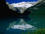 Serene and pristine reflections of snowcapped mountains surrounding Lake Louise, Alberta.