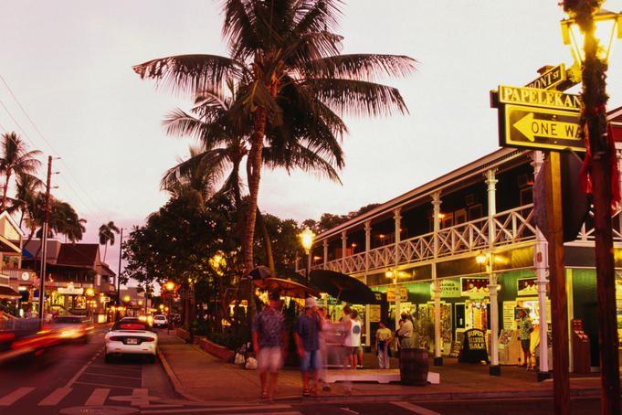 The Pioneer Inn and people shopping on Front Street at dusk.