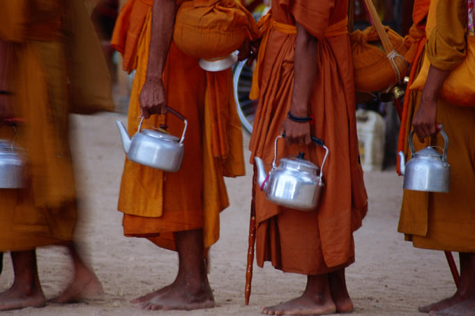 Saffron robed monks queue during an event at the ancient site of Angkor.