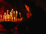 A devotee lighting candles before an icon, inside a Russian Orthodox church.