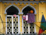 Child plays with basketball on house balcony.