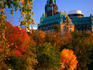 Autumn colours along path on Ottawa River bank, with Parliament building towering in the background