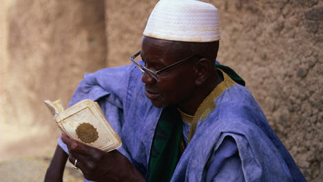 Man reading Koran outside Djenne Mosque