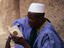 Man reading his Koran outside the Djenne Mosque.