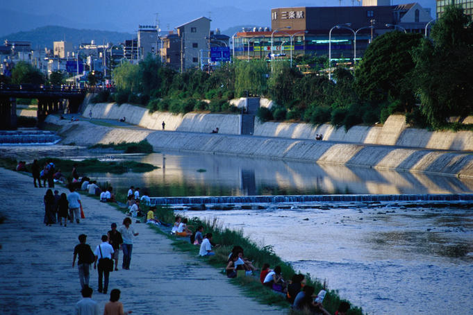 People walking along the banks of the Kamogawa River in Kyoto between shijo and sanjo.