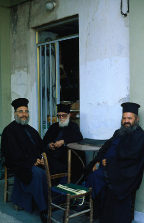 Greek orthodox priests sitting at a coffee shop.