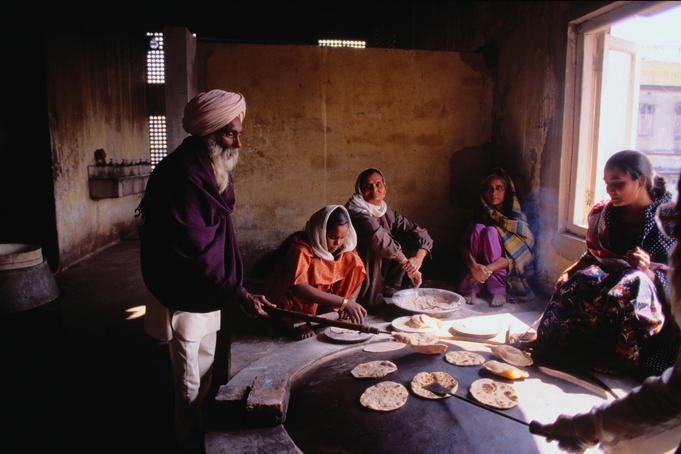 A group of worshippers cook chapatis in the kitchen of the Gurdwara Bara Sikh Temple in Kolkata.