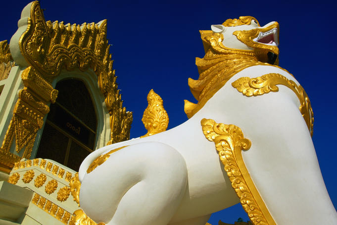 Large white and gold statue of a chinthe at Swedawmyat Paya. The chinthe is a mythical half-lion, half-dragon that guards the entrances to Buddhist monuments.